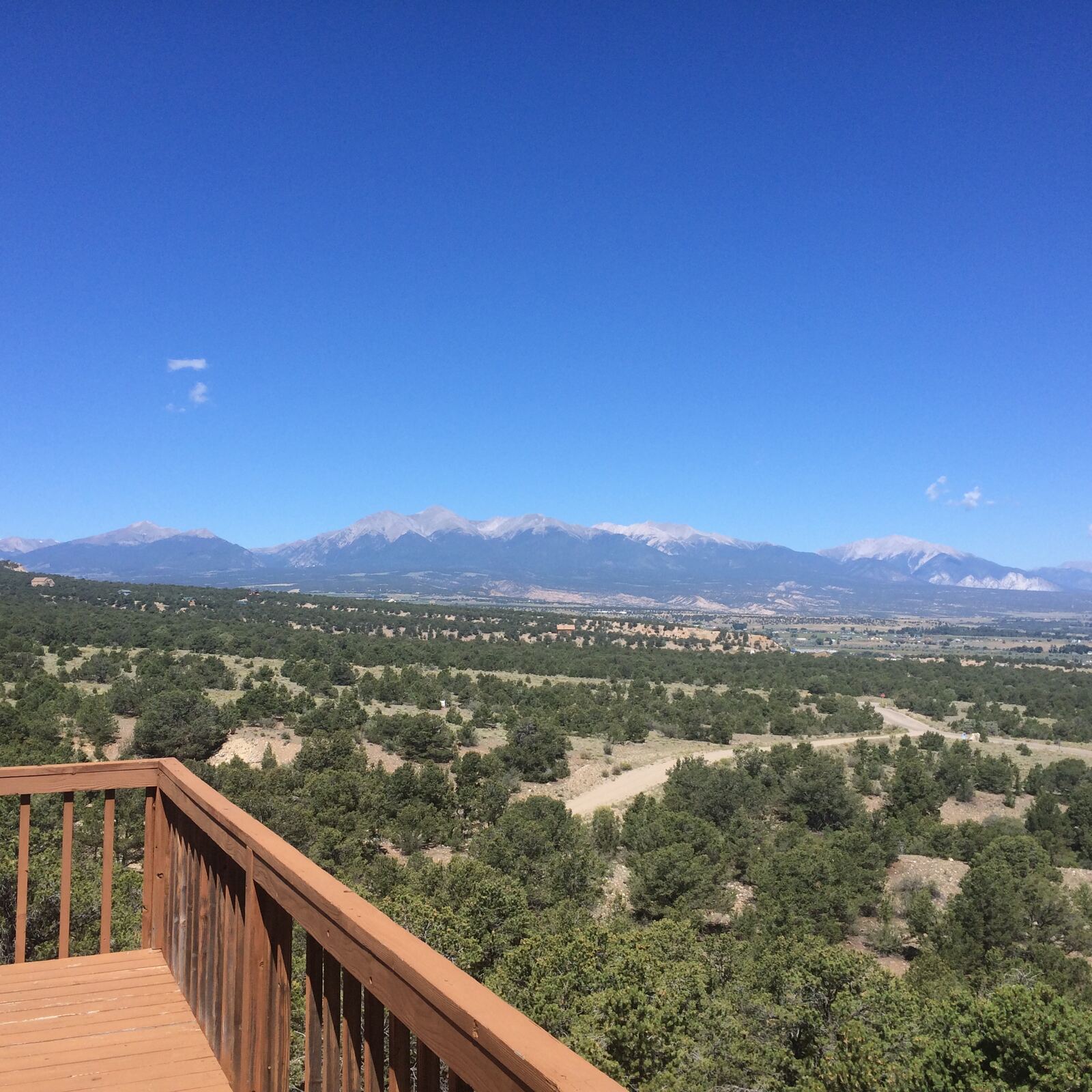 View from the deck on Lot 8 across the neighborhood to the Collegiate Peaks under a blue sky
